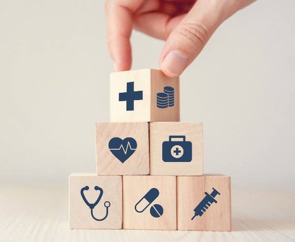 An image of blocks being stacked together to represent the many components of healthcare.